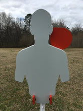 Load image into Gallery viewer, A 12inx21in 3/8in AR500 white and orange steel shooting target with interlocking swinging paddles and a Studded T-post mount outdoors.