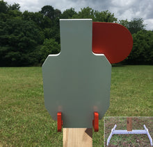 Load image into Gallery viewer, A 7inx12in 3/8in AR500 white and orange steel shooting target with an interlocking swinging paddle, accompanied by a 2x4 mount and stand, set outdoors.