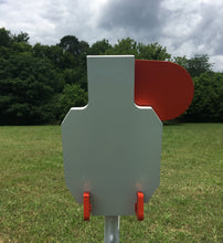 Load image into Gallery viewer, A 7inx12in 3/8in AR500 white and orange steel shooting target with an interlocking swinging paddle and a Studded T-post mount outdoors.