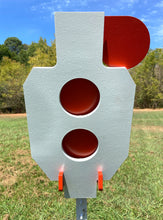 Load image into Gallery viewer, A 9.5inx17in 3/8in AR500 white and orange steel shooting target with interlocking swinging paddles and a Studded T-post mount outdoors.