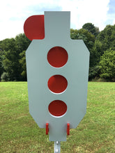 Load image into Gallery viewer, A 10.5inx24in 3/8in AR500 white and orange steel shooting target with interlocking swinging paddles and a Studded T-post mount outdoors.