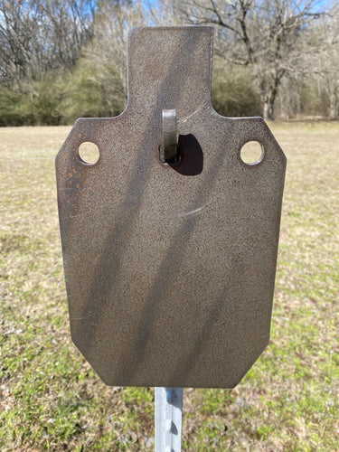 A 7inx12in 3/8in AR500 IDPA steel shooting target with multiple mounting holes mounted on a T-post hook and studded T-Post, placed outdoors on a grassy area.
