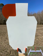 A 12inx20in 3/8in AR500 white and orange steel shooting target with an interlocking swinging paddle, accompanied by a 2x4 mount and stand, set outdoors.